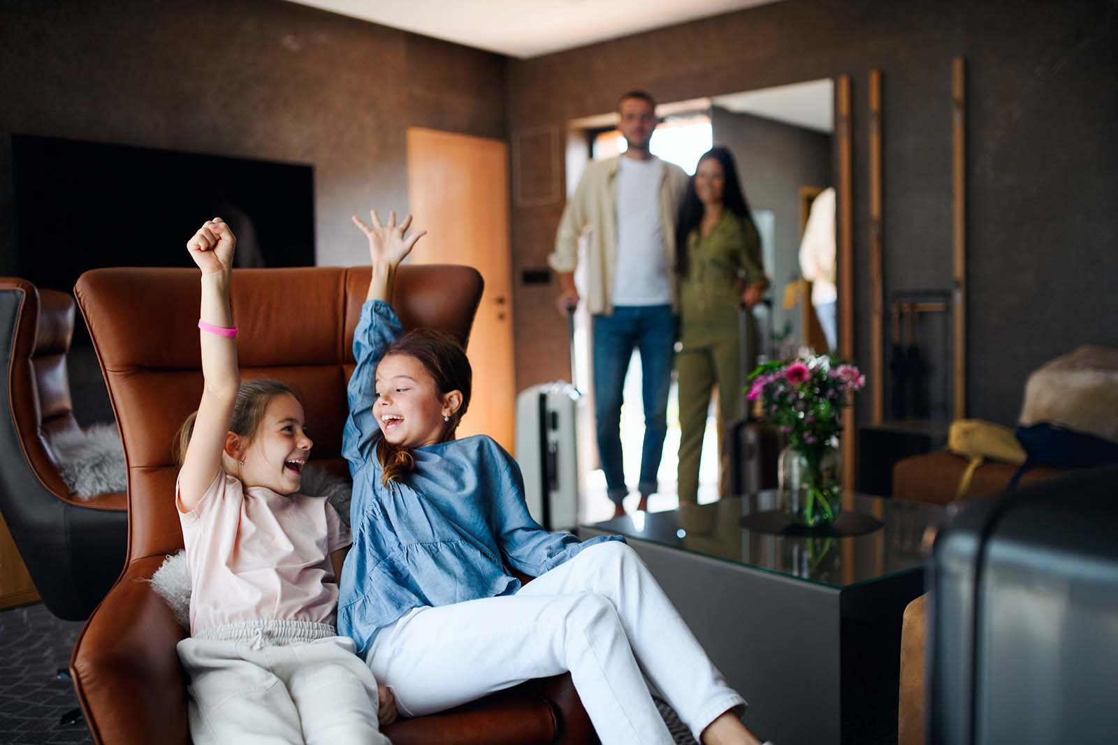 happy-two-sisters-with-parents-enjoying-time-at-luxury-hotel